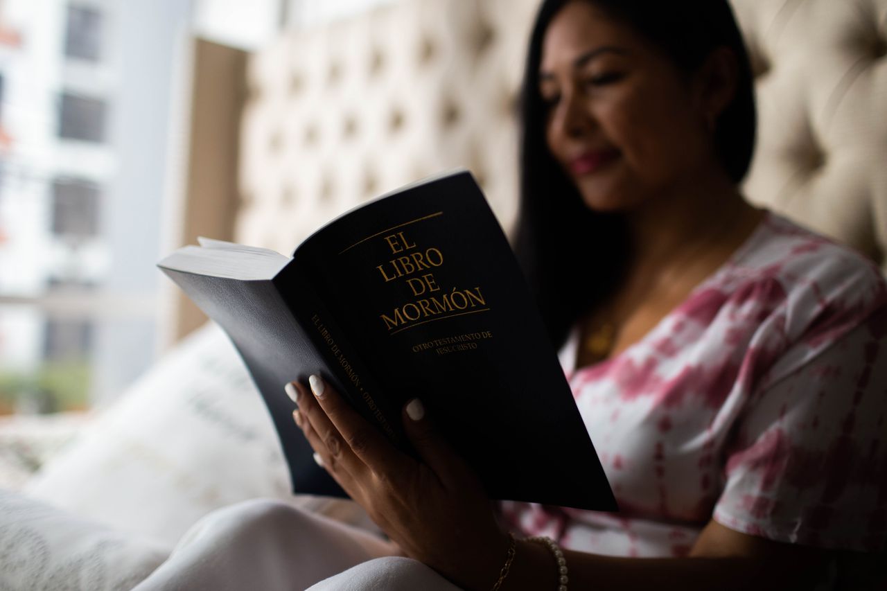 Una mujer lee el Libro de Mormón