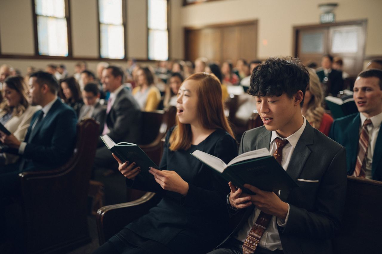 Personas cantando himnos de adoración en la Iglesia
