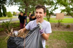 Un joven con una bolsa de hojas de árbol