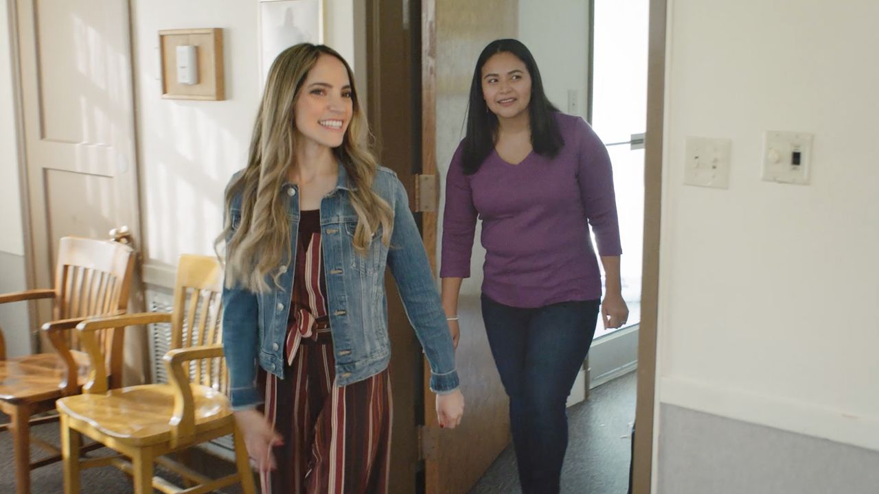 Dos mujeres caminan por una capilla aprendiendo sobre el Evangelio de Jesucristo.