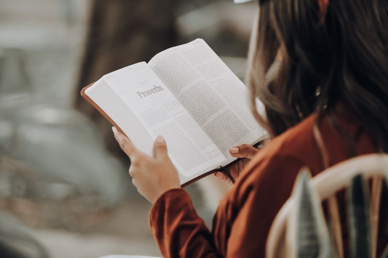 Una mujer lee el libro de Proverbios en la Biblia