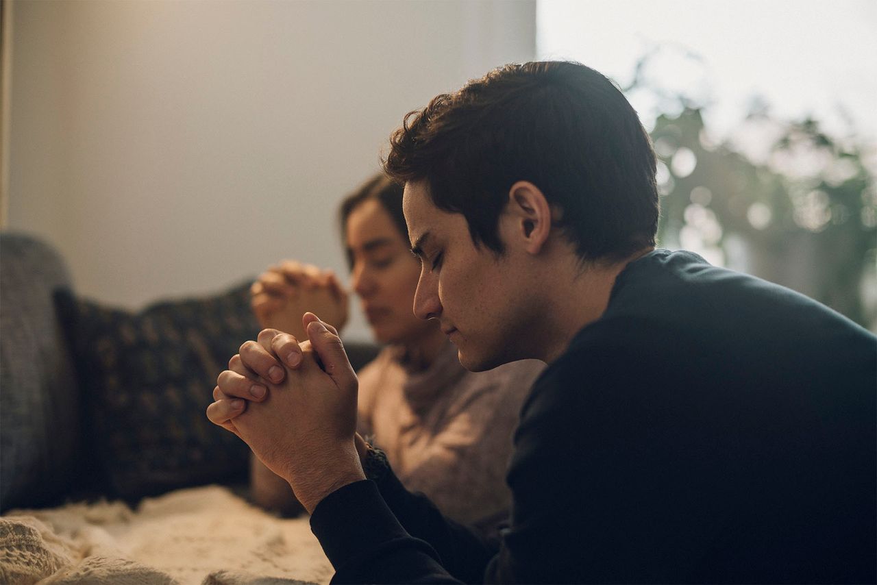 Una pareja se arrodilla en oración